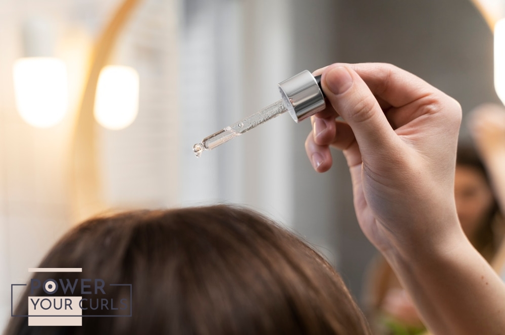 A person applying a serum to their scalp.